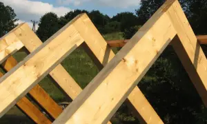 Drewniane krokwie tworzą konstrukcję dachu, ich łączenie w szczycie jest solidne i gotowe na kolejne etapy budowy.