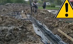 Budowa trwa, pracownicy wylewają beton na zbrojenie, tworząc ławy fundamentowe.