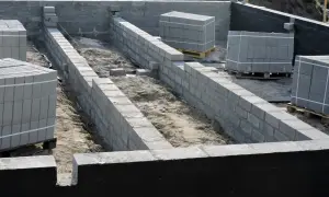 Budowa fundamentów z bloczków betonowych, przygotowanie pod izolację pionową fundamentów.