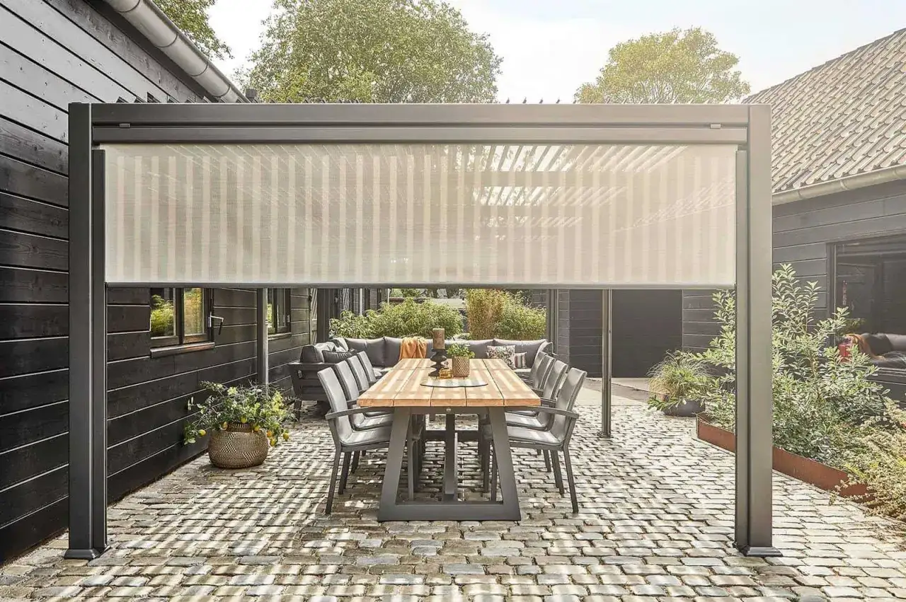 Nowy sposób, jak osłonić taras od wiatru: nowoczesna pergola z zasłoną przeciwwiatrową, tworząca przytulne miejsce do wypoczynku.