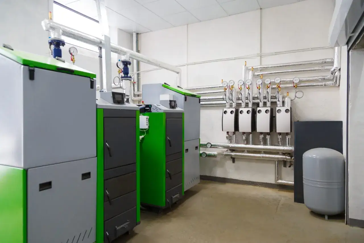 Kotłownia z kilkoma kotłami i rurami. Szacowany koszt instalacji gazowej może zależeć od wielkości i złożoności systemu.