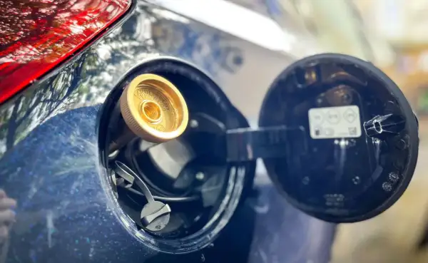Zbliżenie na wlew gazu LPG w samochodzie. Rozważasz koszt instalacji gazowej? To zdjęcie pokazuje, jak wygląda tankowanie.